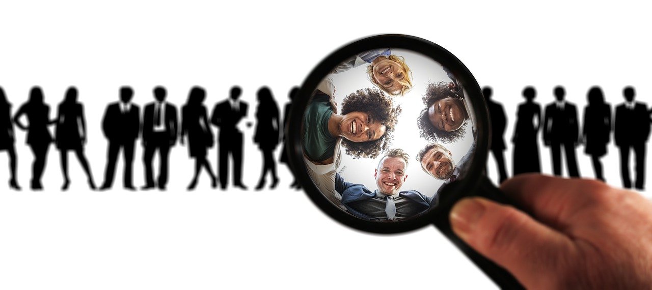 5 Effective Ways to Find New Clients - a magnifying lens illuminates potential new clients from a line-up of silhouettes. 