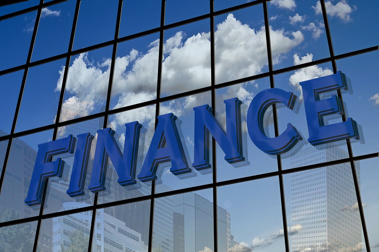 5 Funding options for your start-up - A glass-fronted building with the word "FINANCE" reflects clouds and city buildings.
